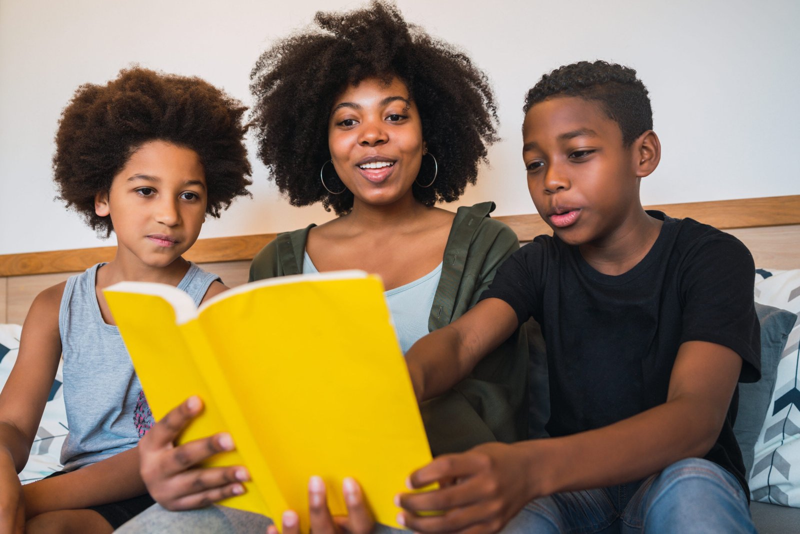 low angle view mother with sons reading book home 1 scaled